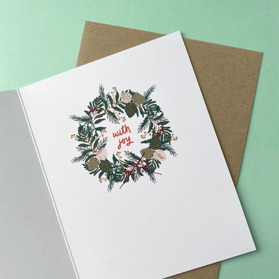 Inside of Christmas card illustrated with a wreath and the words with joy