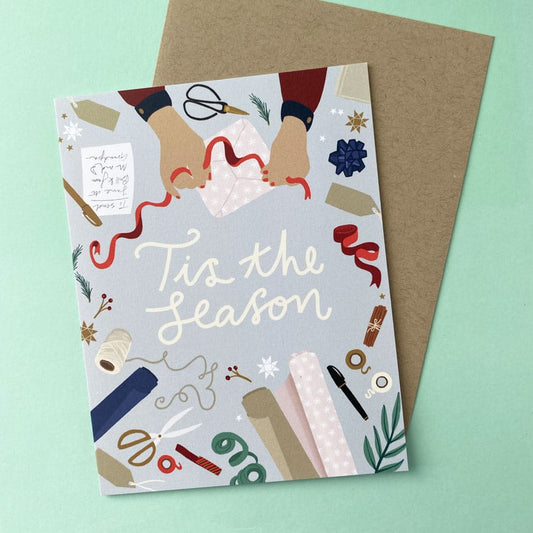 Christmas card illustrated with a festive present wrapping scene with a kraft envelope