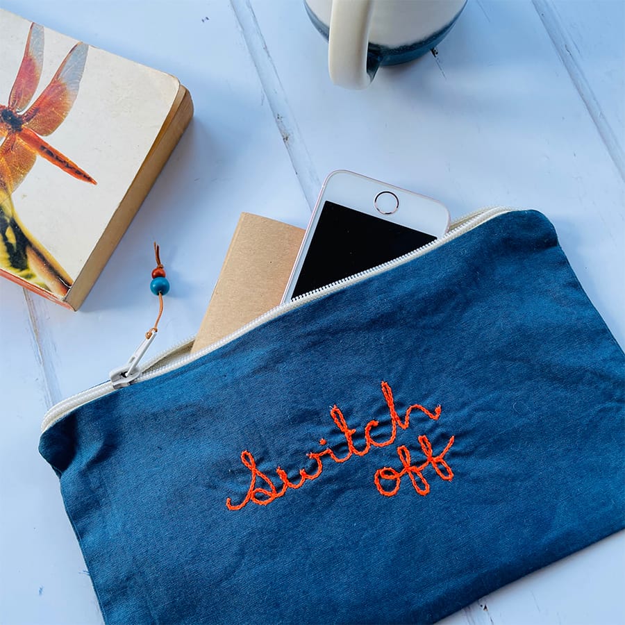 Hand dyed zipper pouch embroidered with the phrase switch off