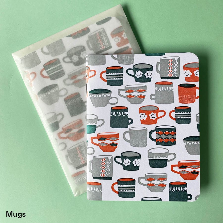 Pocket sized notebook with illustrated letterpress notebook depicting different mugs in dark grey light grey and red