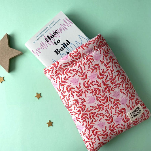 Aerial image of a Paper + Word padded book sleeve in a red and pink leaf and bird pattern