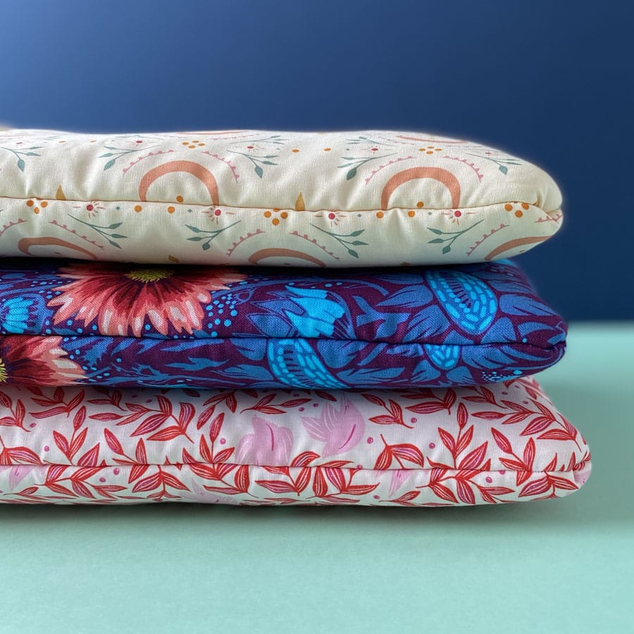 Three different patterned padded book sleeves in a stack